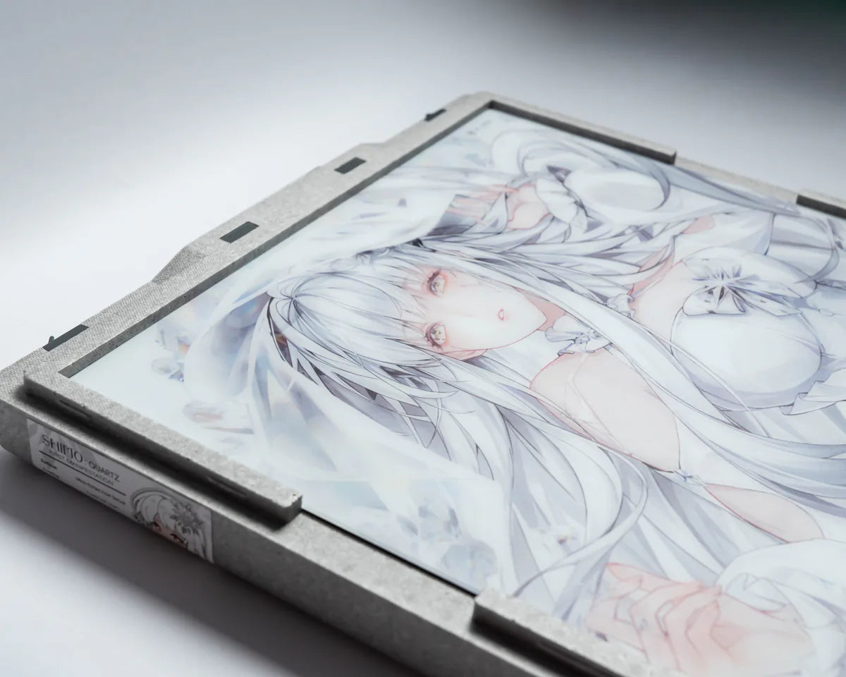 Three-quarter view of the Shimo-Quartz glasspad seated in its Vault, the printed white-haired Shimo character reading through the glass inside a pale grey foam frame.